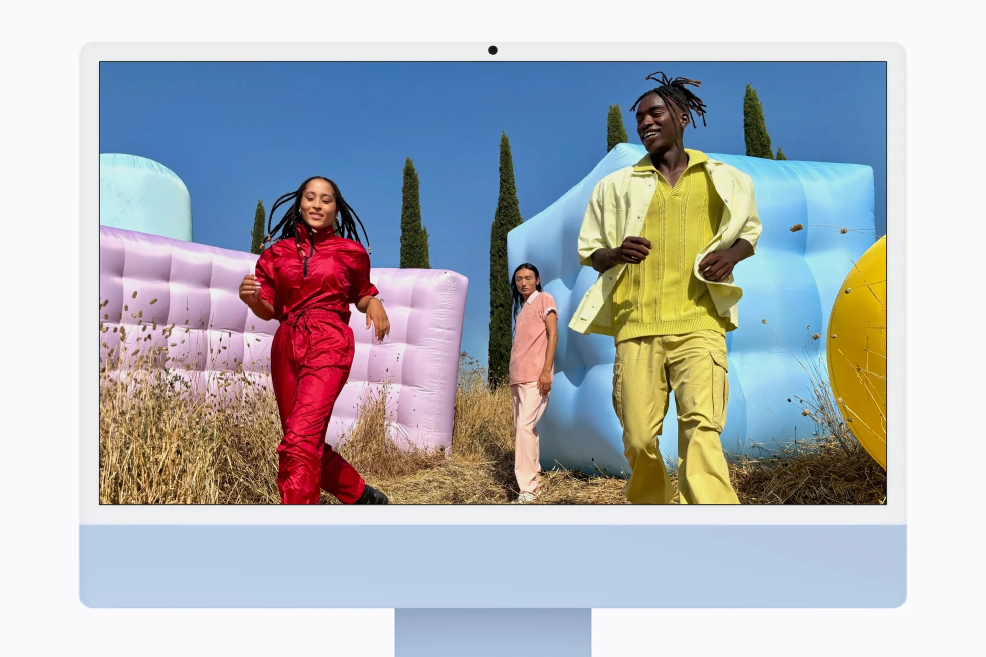 iMac สีฟ้ามองจากด้านหน้า พร้อมภาพบุคคลสามคนบนหน้าจอ